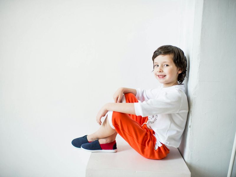 Person doing a dynamic stretch in a bright, minimalist room.