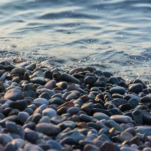 Smooth stones stacked by a calm water surface.